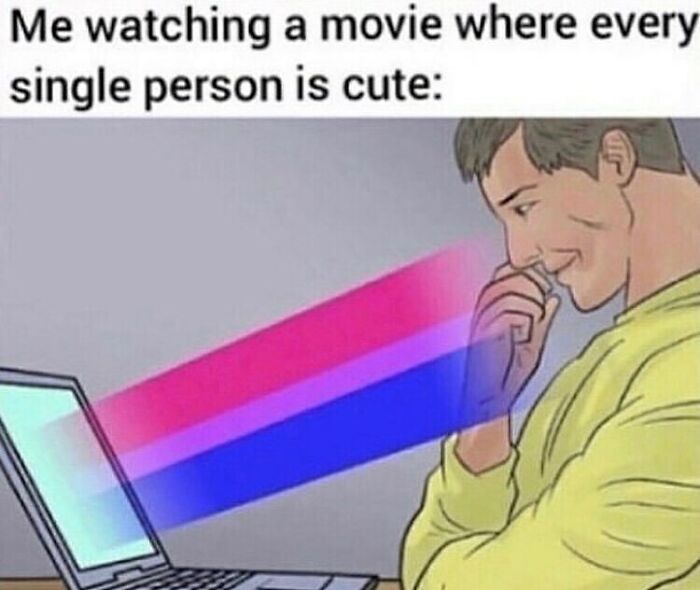 Person smiling at a laptop screen with colorful light beams, illustrating LGBTQ+ memes and humor online.