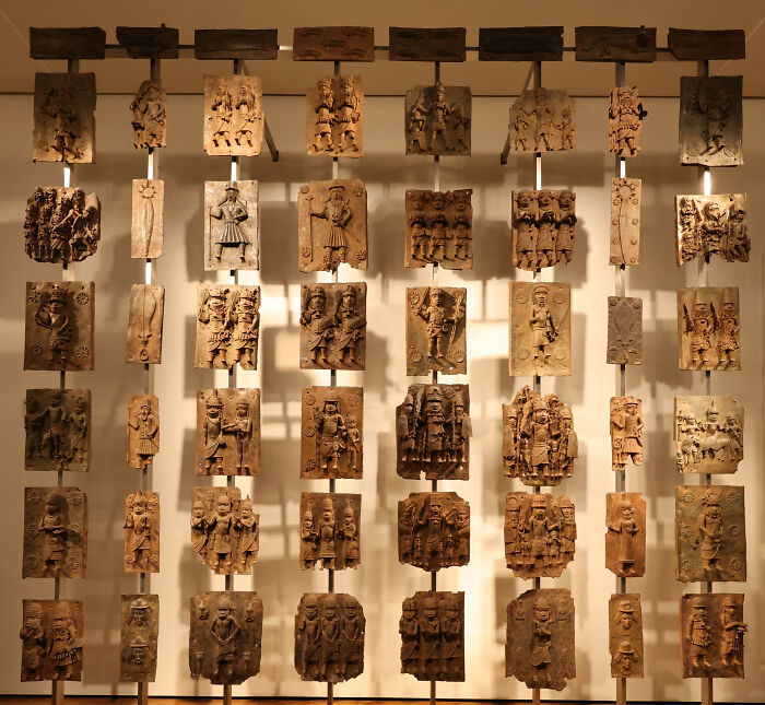 Ancient foreign artifacts displayed in the British Museum featuring intricate carved wooden panels in rows.