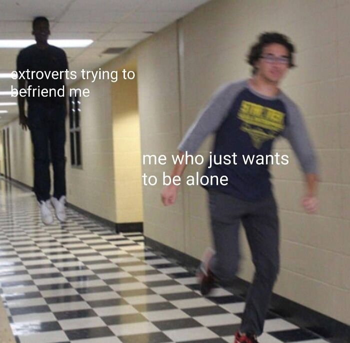 Two young men in a hallway with text about extroverts and social anxiety memes showing preference to be alone.