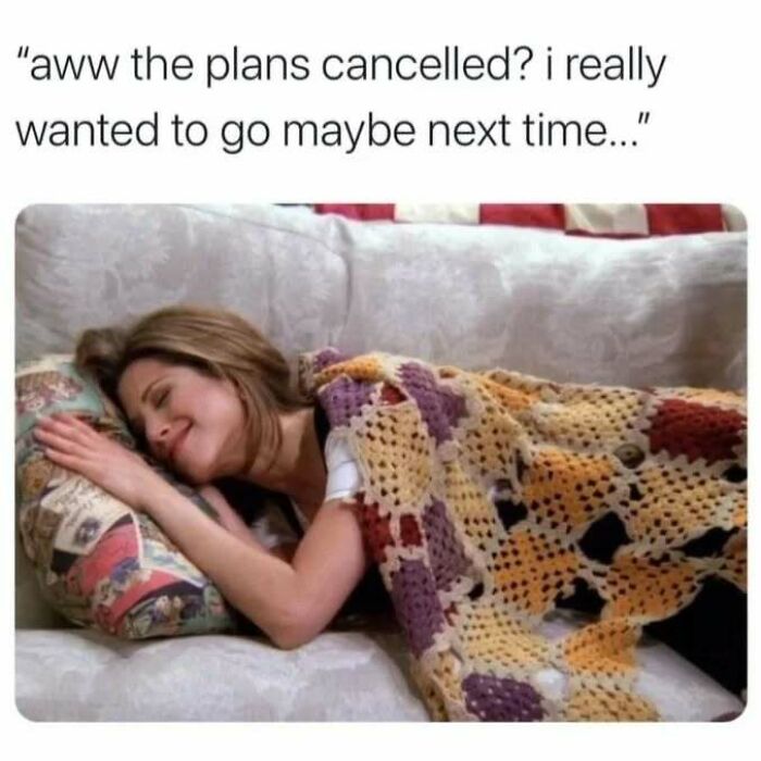 A woman smiling and lying on a couch covered with a blanket, relatable social anxiety meme about canceled plans.