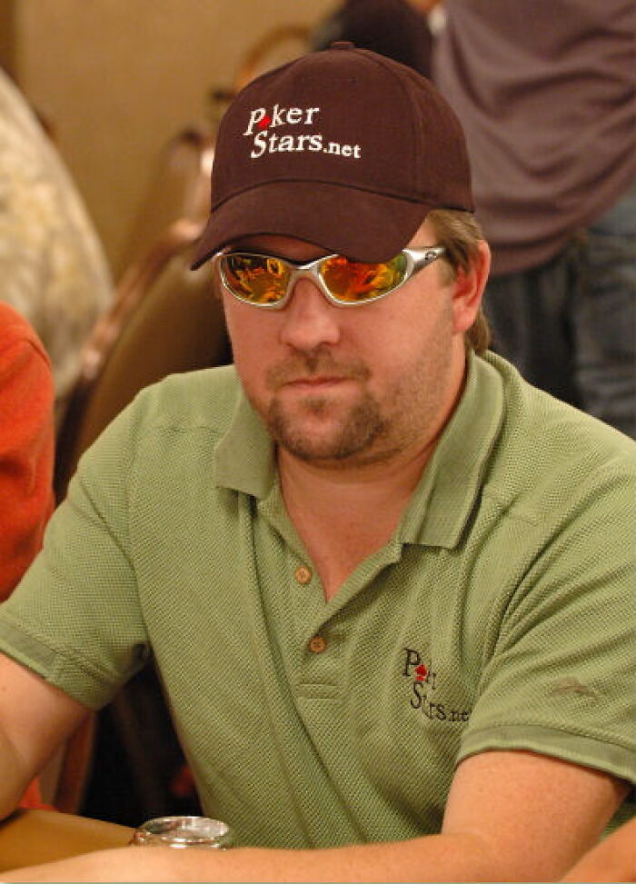 Man wearing PokerStars cap and sunglasses playing poker indoors, illustrating crazy but real historical events.
