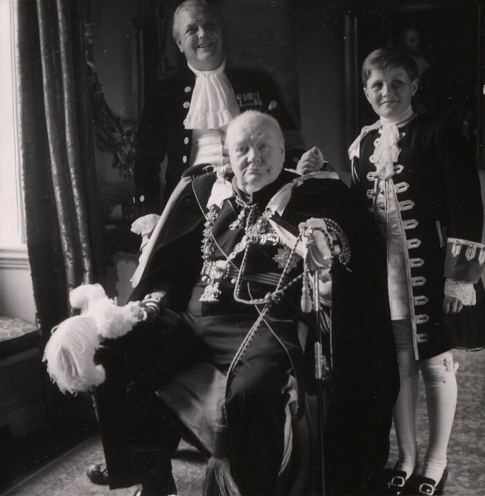 Black and white rare historical photograph showing three men dressed in traditional elaborate formal attire indoors.