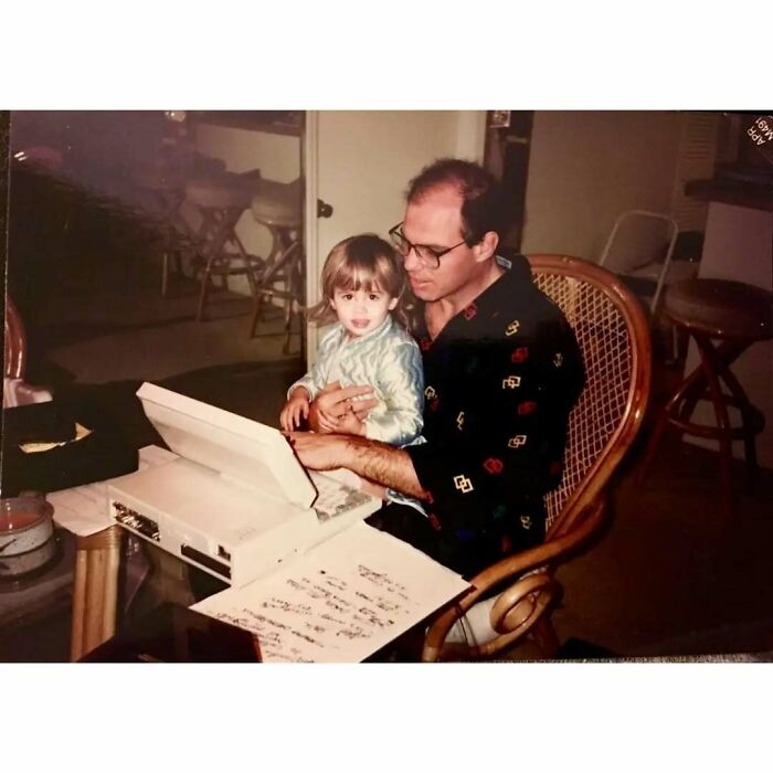 Vintage dad with child using typewriter at home, capturing the essence of old school cool dads from the past.