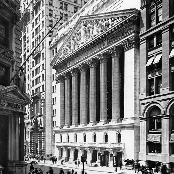 Historic old architecture with tall Corinthian columns and detailed sculptures in a classic urban city street scene.