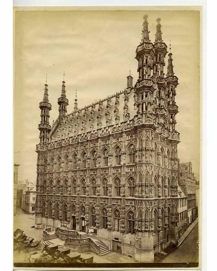 Intricate old architecture of a historic gothic-style building with detailed stone carvings and tall spires.