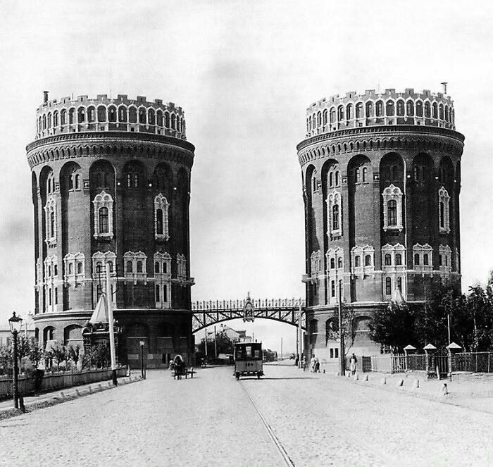 Two historic round towers connected by an ornate bridge, showcasing old architecture from a bygone era.