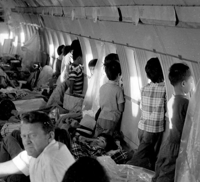 Children and adults crowded inside an airplane cabin, illustrating surprising facts about historical travel conditions.