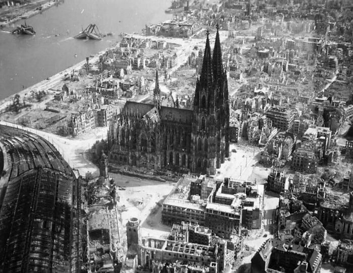 Aerial view of old architecture featuring a historic cathedral surrounded by a city in ruins after destruction.