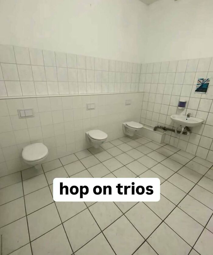 Restroom with three wall-mounted toilets in a row and a small sink, showcasing nerdy and weird memes humor.