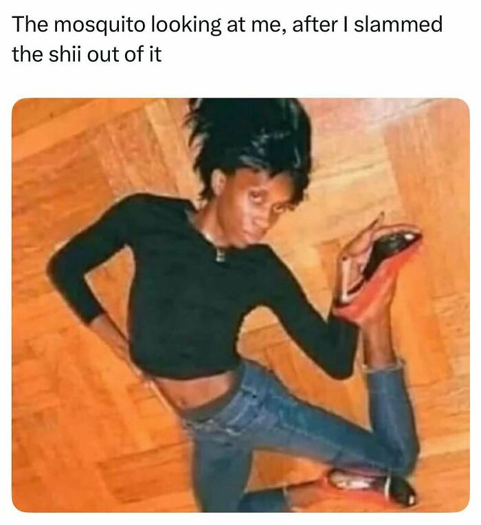 Person in black top and jeans lying on wooden floor, striking a chaotic pose, fitting random and chaotic memes keyword.