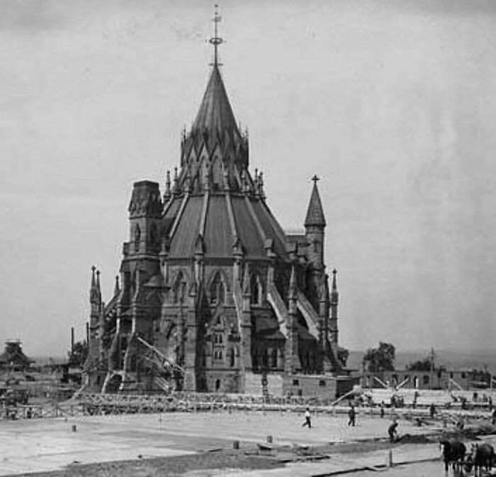 Black and white photo of old architecture featuring a large Gothic-style building with spires and detailed stonework.