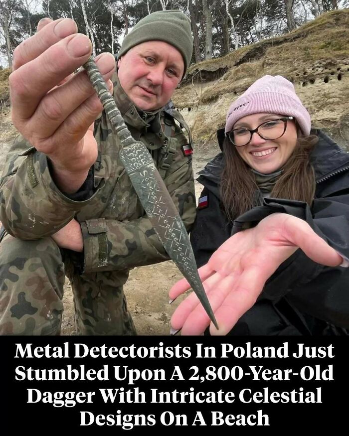 Two metal detectorists in Poland holding a 2,800-year-old dagger with intricate designs, showcasing interesting facts.