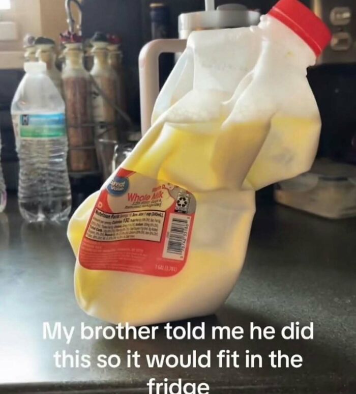 Milk jug squeezed and twisted to fit better in fridge, a puzzling and strange photo that makes no sense but you can’t stop looking