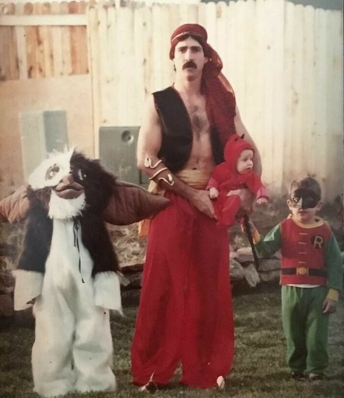 Dad dressed as Aladdin with children in various costumes, showcasing old school cool vintage family Halloween style.