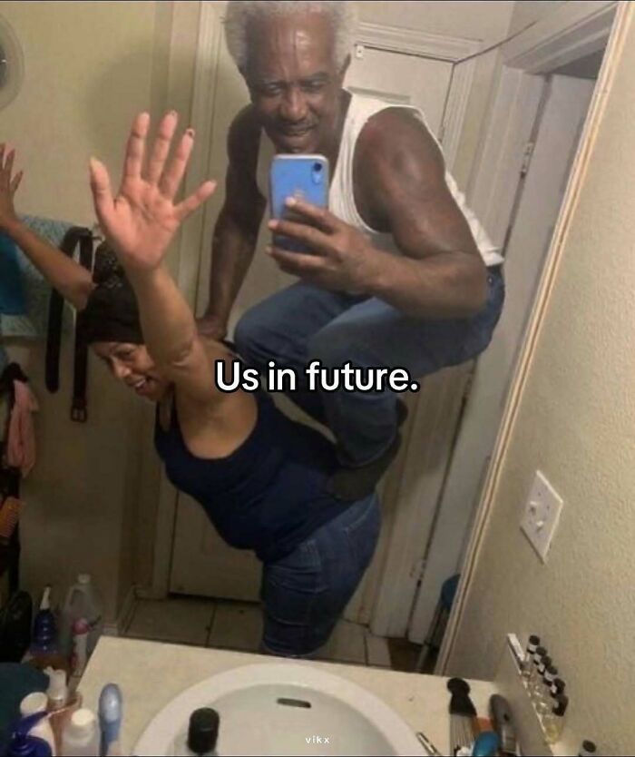 Two people posing humorously in a bathroom mirror, creating one of the pics that make no sense at all.