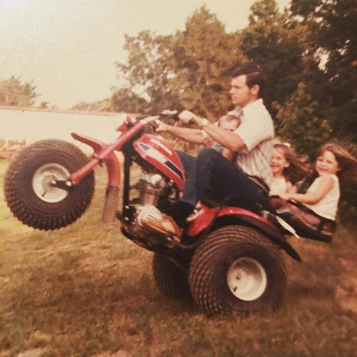 Dad from the past riding vintage ATV with children, showcasing classic old school cool family fun outdoors.