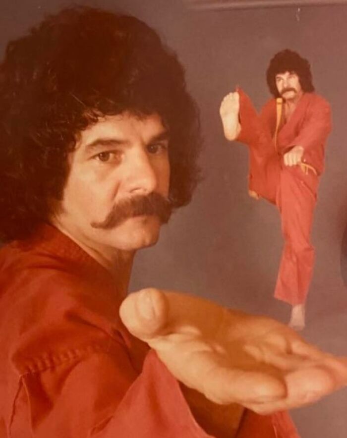 Vintage photo of a dad in martial arts pose with curly hair and mustache, showcasing old school cool style and attitude.