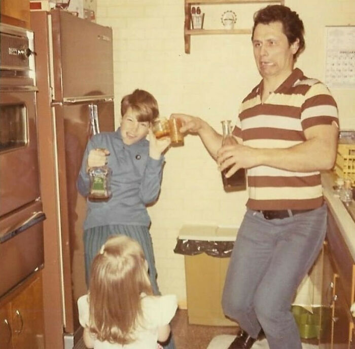 Vintage photo of old school cool dad and children enjoying drinks together in a retro kitchen setting.