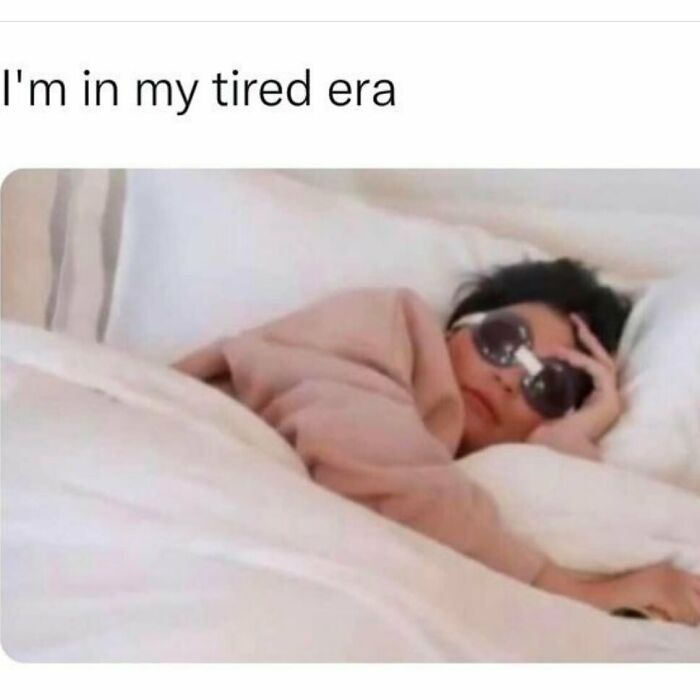 Person lying in bed wearing sunglasses and a blanket, a funny meme reminding not to take life too seriously.