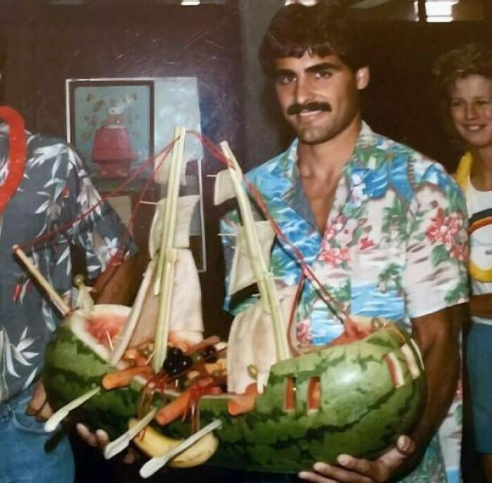Vintage dad in a floral shirt holding a watermelon sailboat, showcasing classic old school cool style from the past.