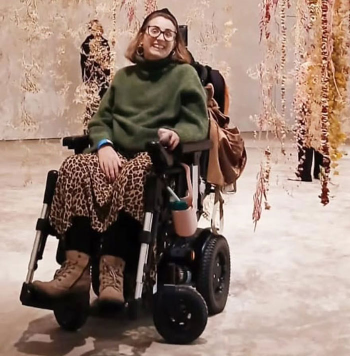 Woman in a wheelchair wearing glasses and leopard print skirt, symbolizing mom struggles and protecting kids from breathing issues. - 7