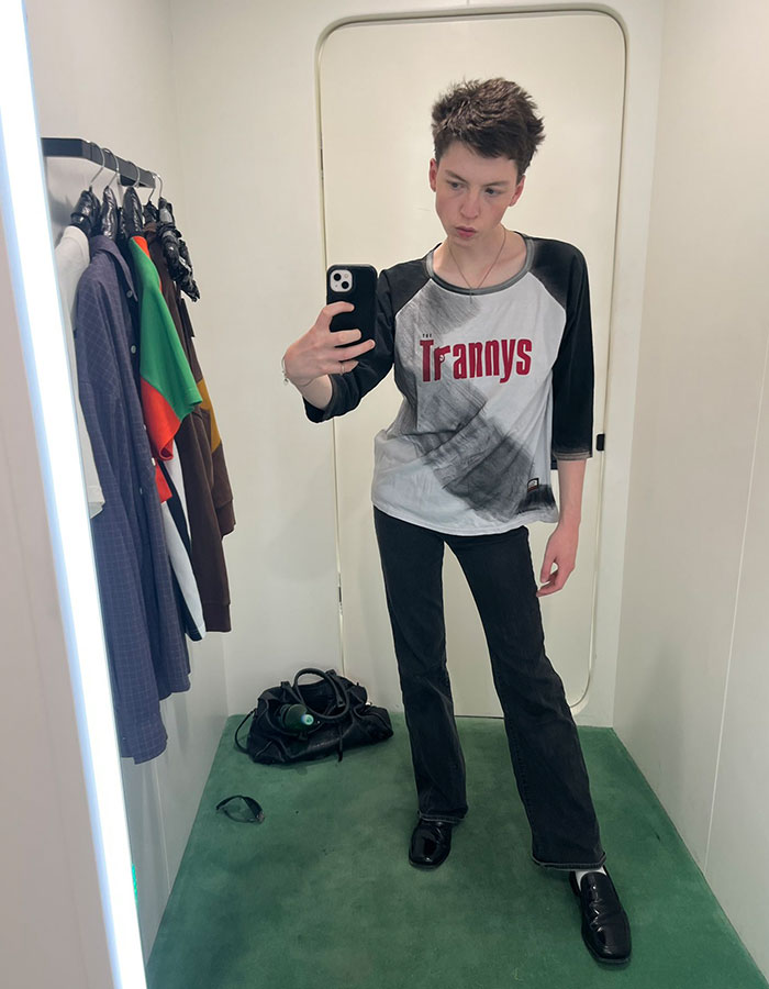 Model taking a mirror selfie in casual clothes, illustrating story of transition and detransition at age 15. - 7
