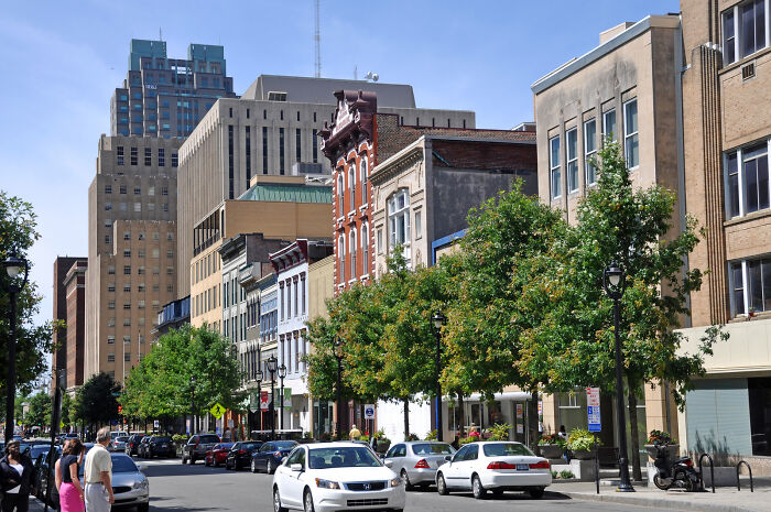 Downtown city street with classic and modern buildings, cars parked along the road, illustrating best places to live in the USA.