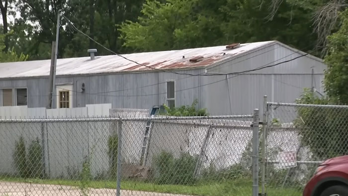 Chain-link fence surrounding a residential trailer, scene linked to trafficking victim being dragged back to captivity. Chain-link fence surrounding a residential trailer, scene linked to trafficking victim being dragged back to captivity.