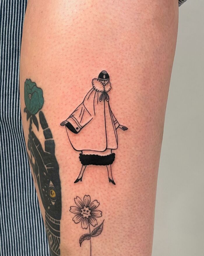 Minimalist black line tattoo of a person in a cloak and a flower on the arm, showcasing best tattoos designs.