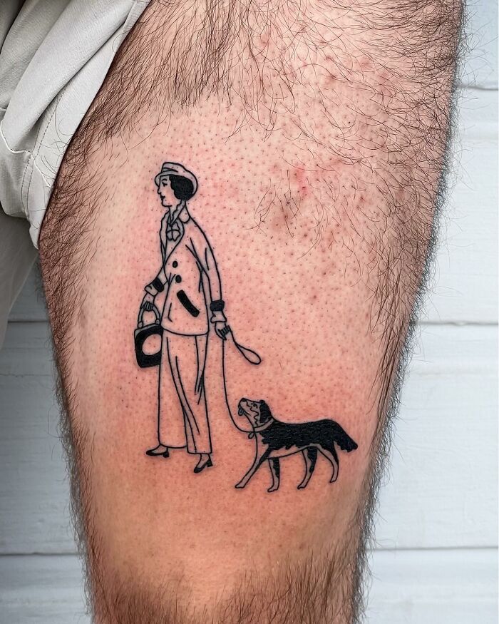 Minimalist tattoo of a person walking a dog in black ink on a hairy leg, showcasing one of the best tattoos trending online.