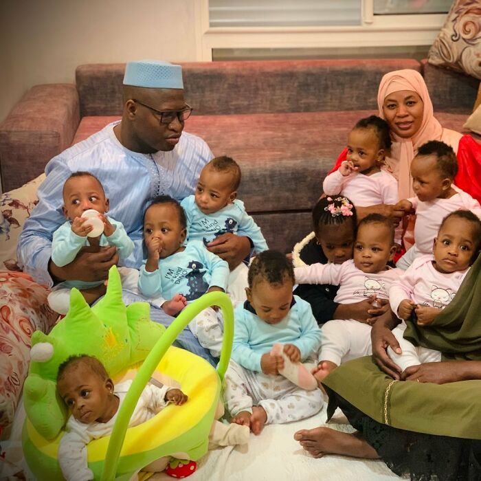 Parents with the world&rsquo;s first surviving nonuplets, nine toddlers playing and sitting together at home.