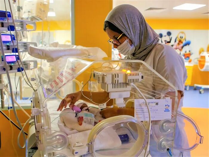 Nurse caring for the world&rsquo;s first surviving nonuplets baby in a hospital incubator with medical monitoring equipment nearby