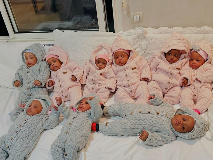 The world&rsquo;s first surviving nonuplets growing up fast wearing cozy pink and gray outfits on a white couch.