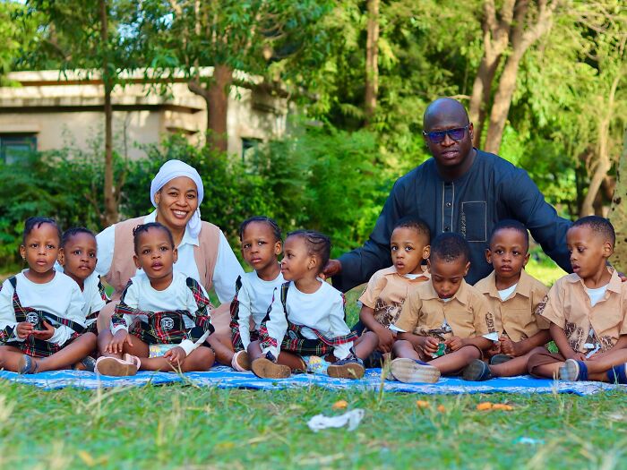 The world&rsquo;s first surviving nonuplets sitting outdoors with parents, growing up fast at age four in a lush green setting