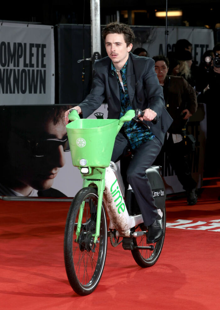 Celebrity riding a Lime bike on a red carpet, showcasing how some celebrities choose not to overspend despite wealth.