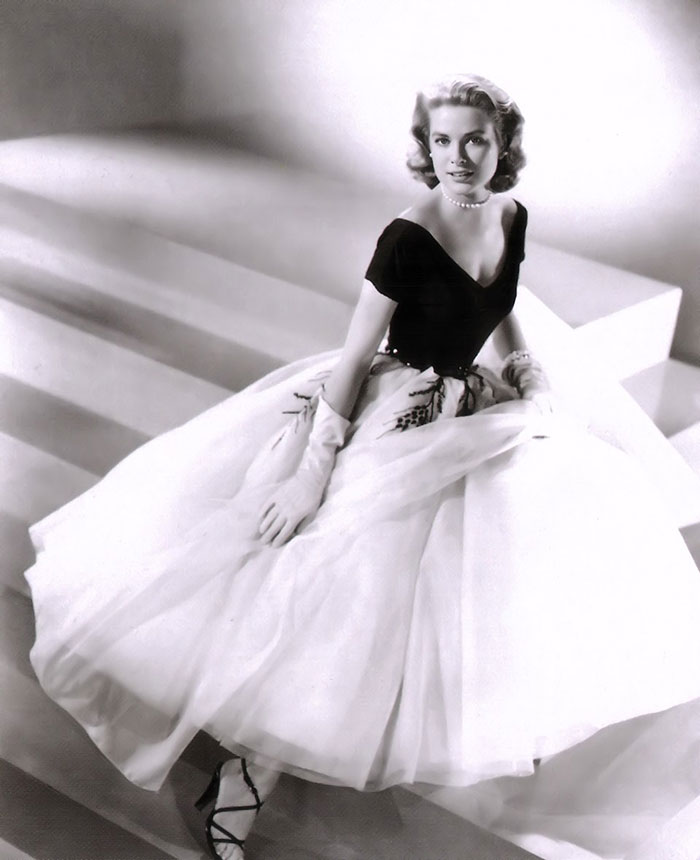 Grace Kelly in a classic glamorous black and white dress iconic of her legendary Hollywood style.