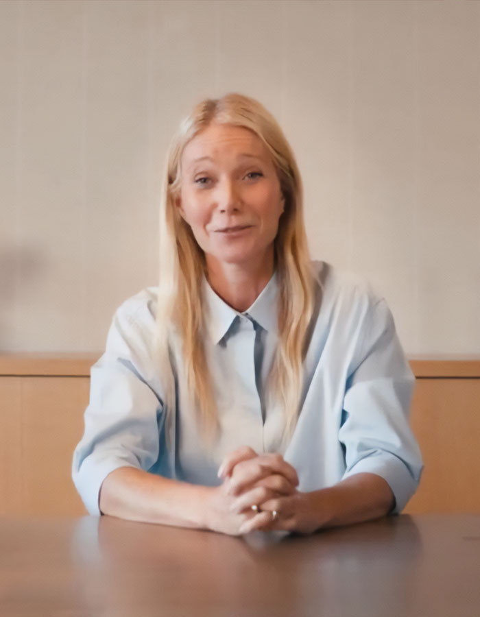 Gwyneth Paltrow sitting at a table, wearing a light blue shirt, discussing Coldplay frontman and astronomer drama. Gwyneth Paltrow sitting at a table, wearing a light blue shirt, discussing Coldplay frontman and astronomer drama.