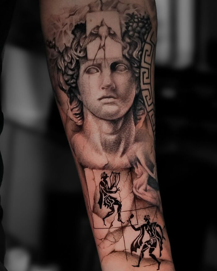 Realistic black and grey tattoo of a classical statue head with ancient Greek figures on a forearm, showcasing best tattoos.