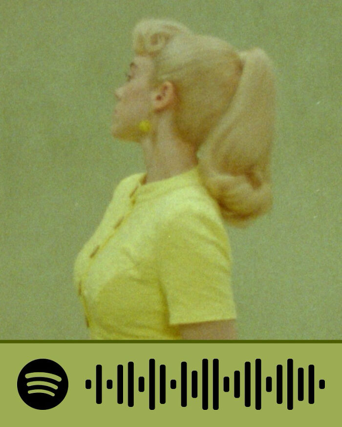 Woman in yellow outfit with vintage hairstyle, representing emotional songs that hurt so good but keep listeners engaged.