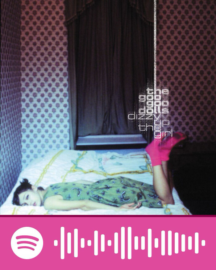 Woman lying on a bed in a patterned room, representing songs that hurt so good listened to by netizens.