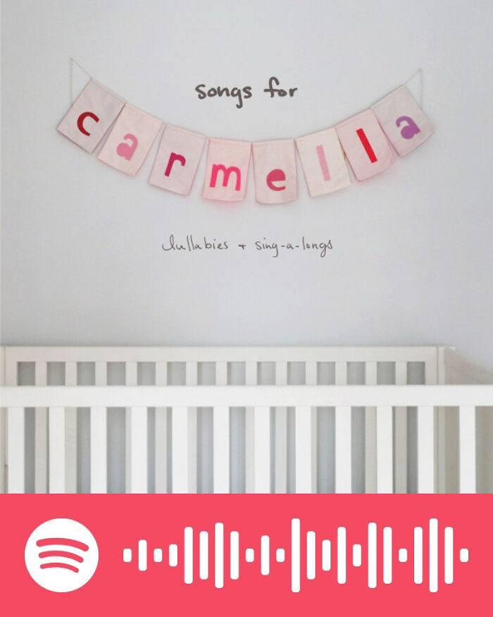 White crib below a banner spelling Carmella with text about lullabies, representing songs that hurt so good playlist on Spotify.
