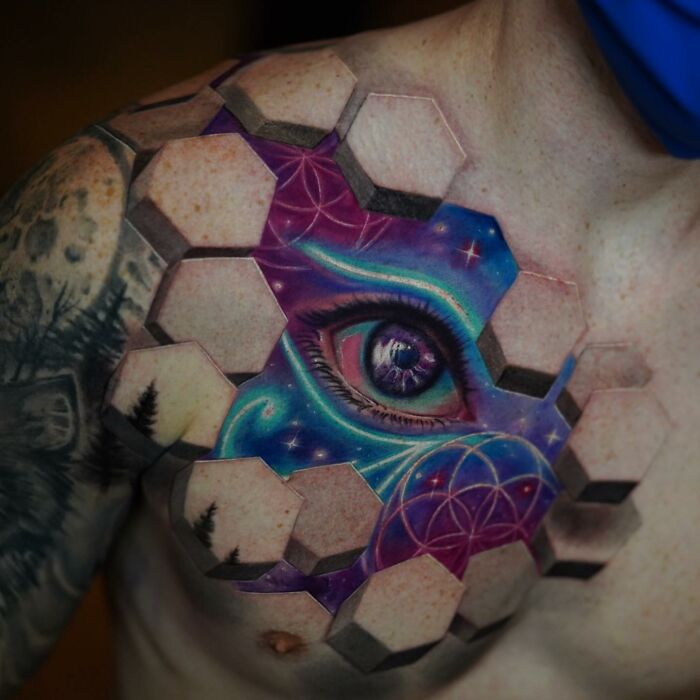 3D tattoo on chest by Jesse Rix featuring a portal-like design with a detailed eye and cosmic elements in vibrant colors.