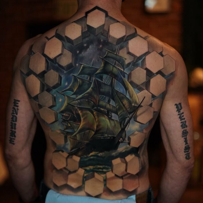 3D tattoos on back featuring a ship emerging from a geometric portal design, showcasing detailed and realistic body art.