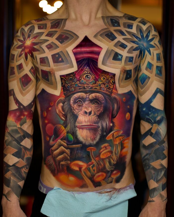 3D tattoos by Jesse Rix featuring a crowned chimpanzee with cosmic and mushroom elements on a full chest and arms.