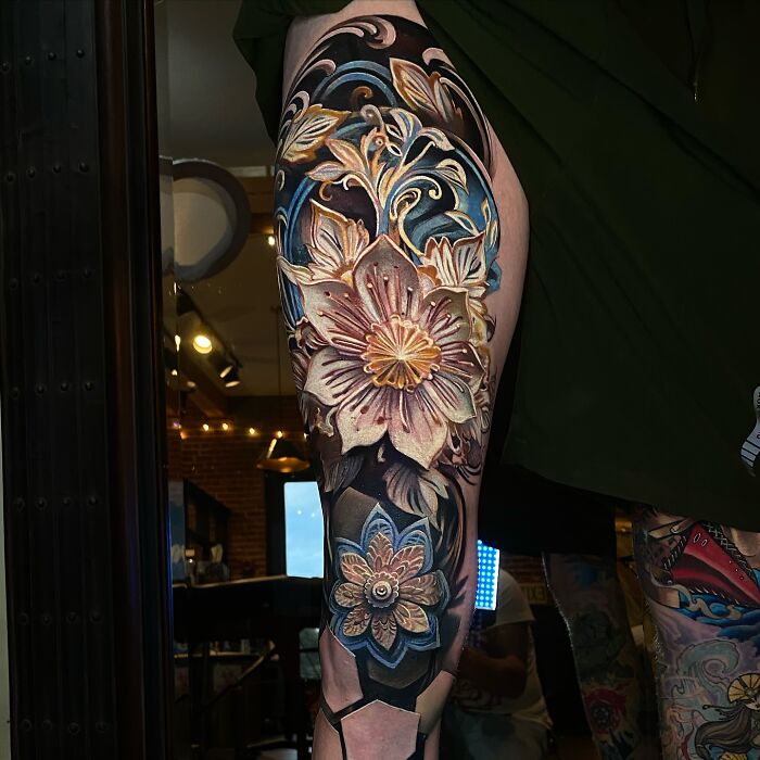 3D tattoo of intricate flowers on a leg, featuring vivid colors and realistic shading, resembling a portal to another world.