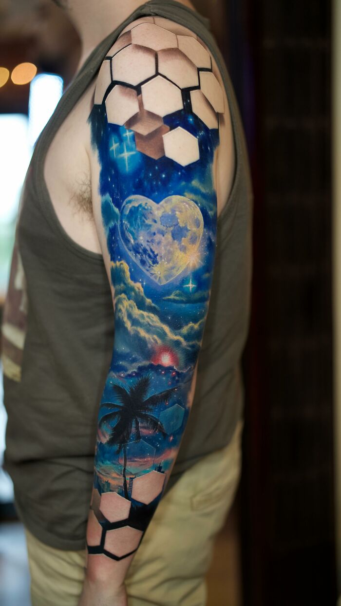 Sleeve tattoo featuring 3D hexagons and a cosmic heart with stars and palm tree in vivid colors by Jesse Rix.