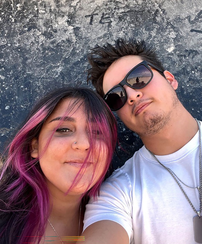 Two young adults posing for a selfie, related to 7-Eleven employee and police update on tragic incident.