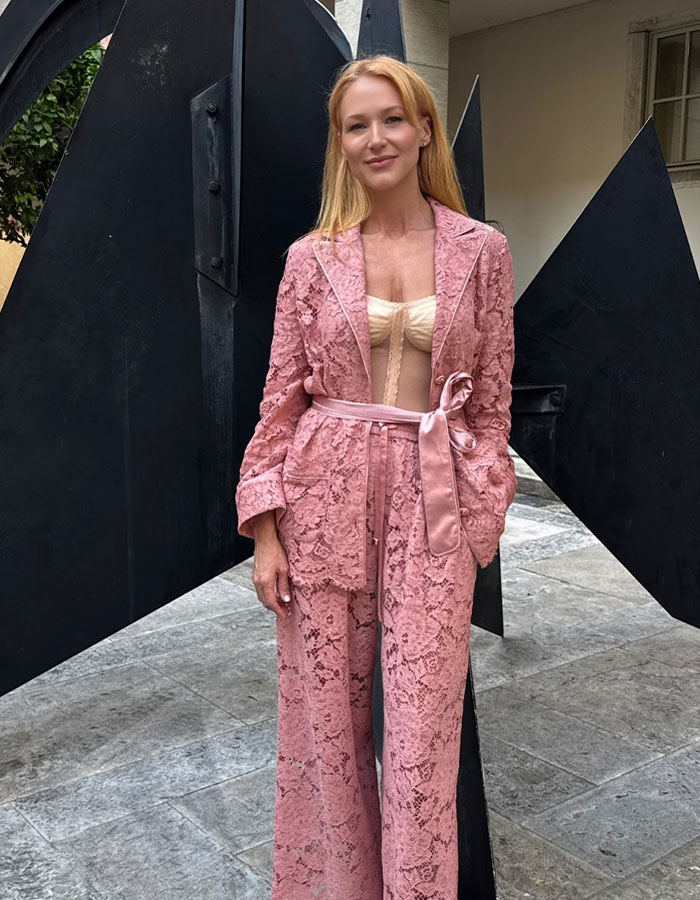 Jewel, 51, posing outdoors in a pink lace suit and beige top, showcasing her racy bombshell makeover style.