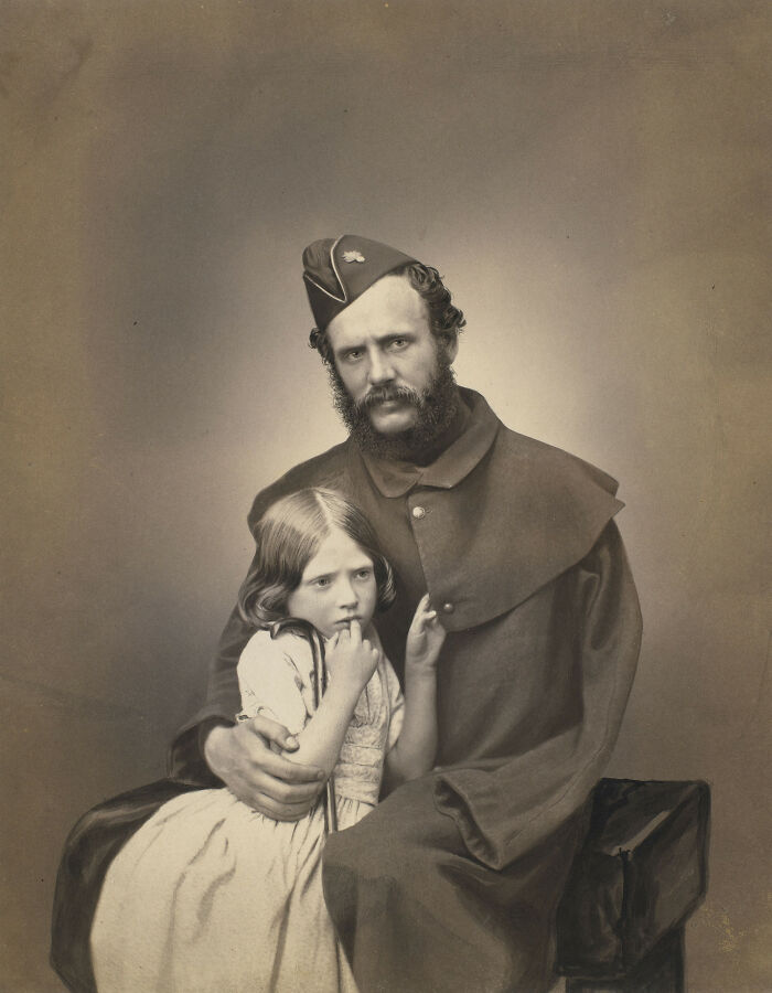 19th century historical photo of a man in uniform gently holding a young girl, bringing history to life through imagery.