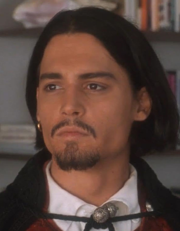 Young Johnny Depp with long hair and goatee, portraying a serious expression reflecting his dark childhood with violent mom.